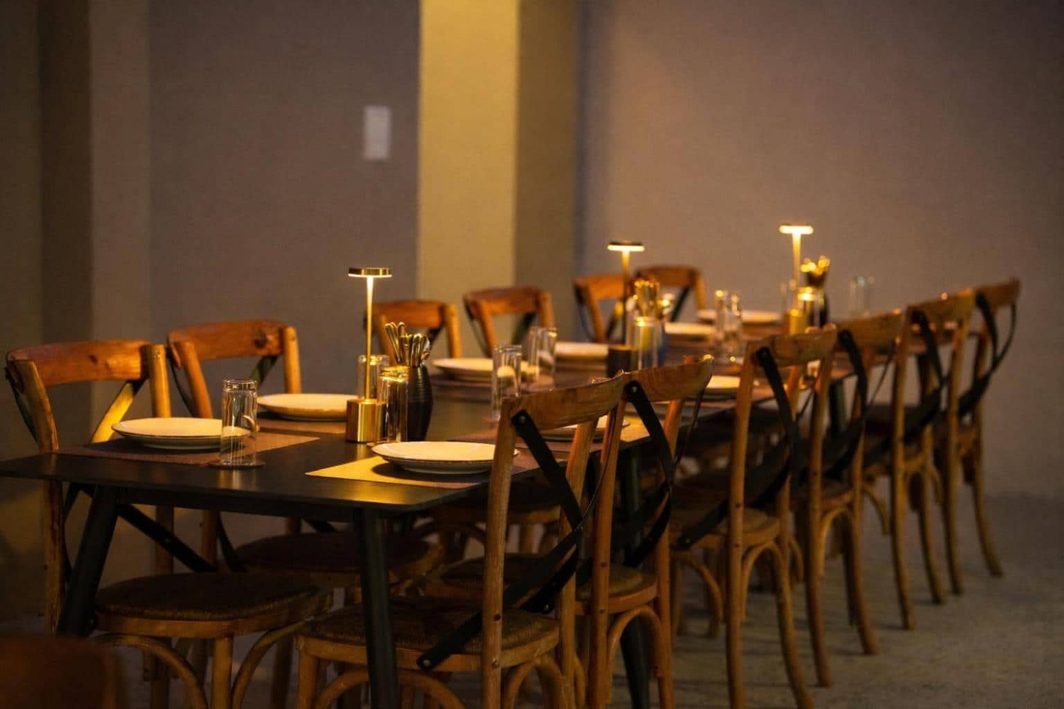 Long candle-lit table set for a group dinner