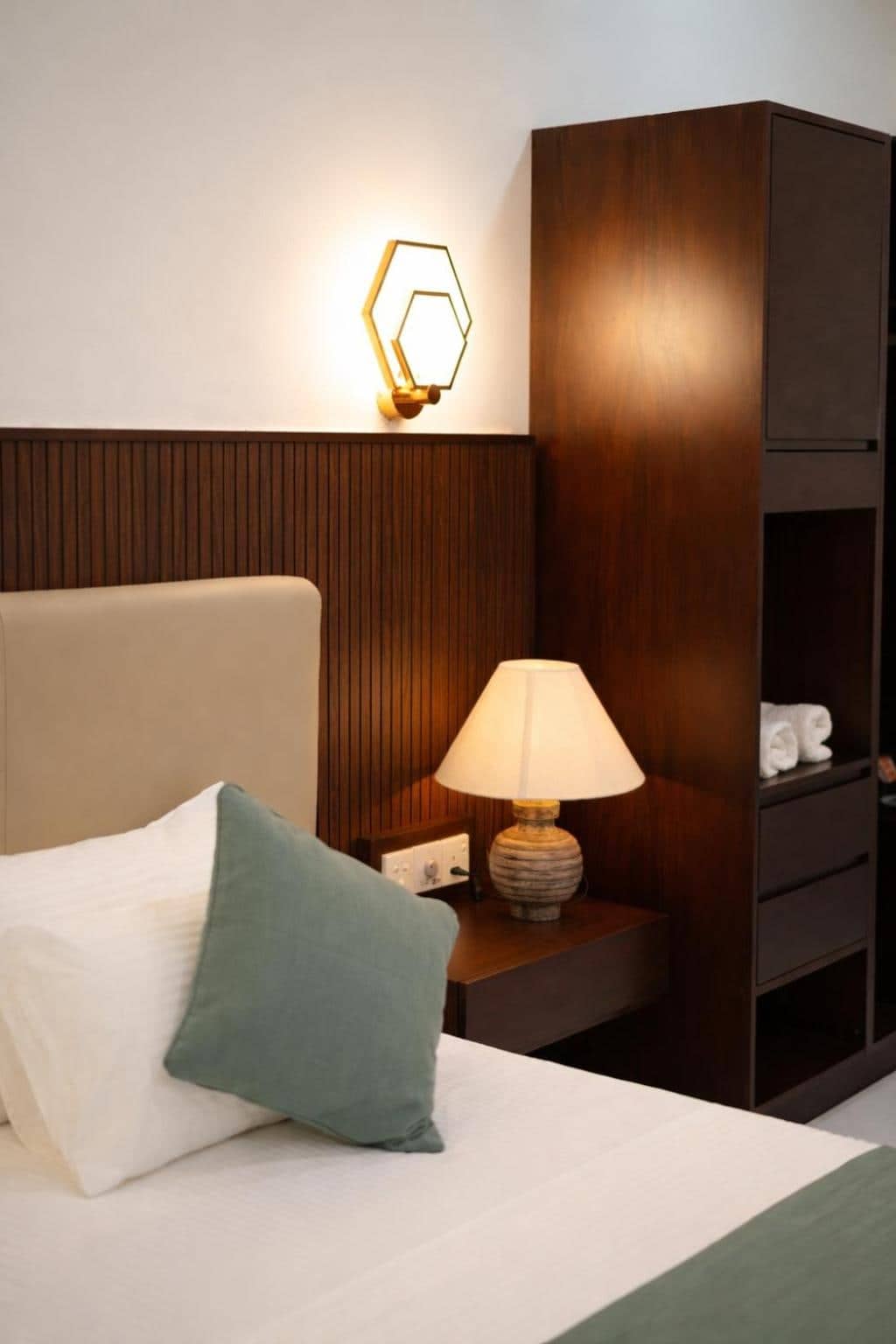 Bedside table with lamp and warm timber panelling