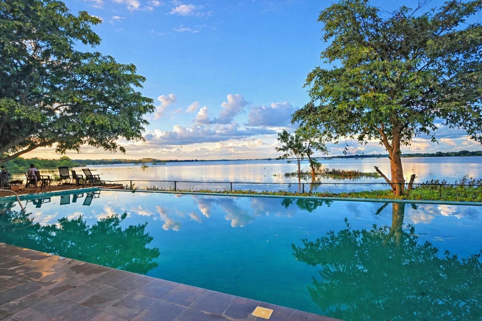 Infinity pool at Yaazoraa, a lakeside hotel in Anuradhapura, reflecting the sky over Nuwara Wewa