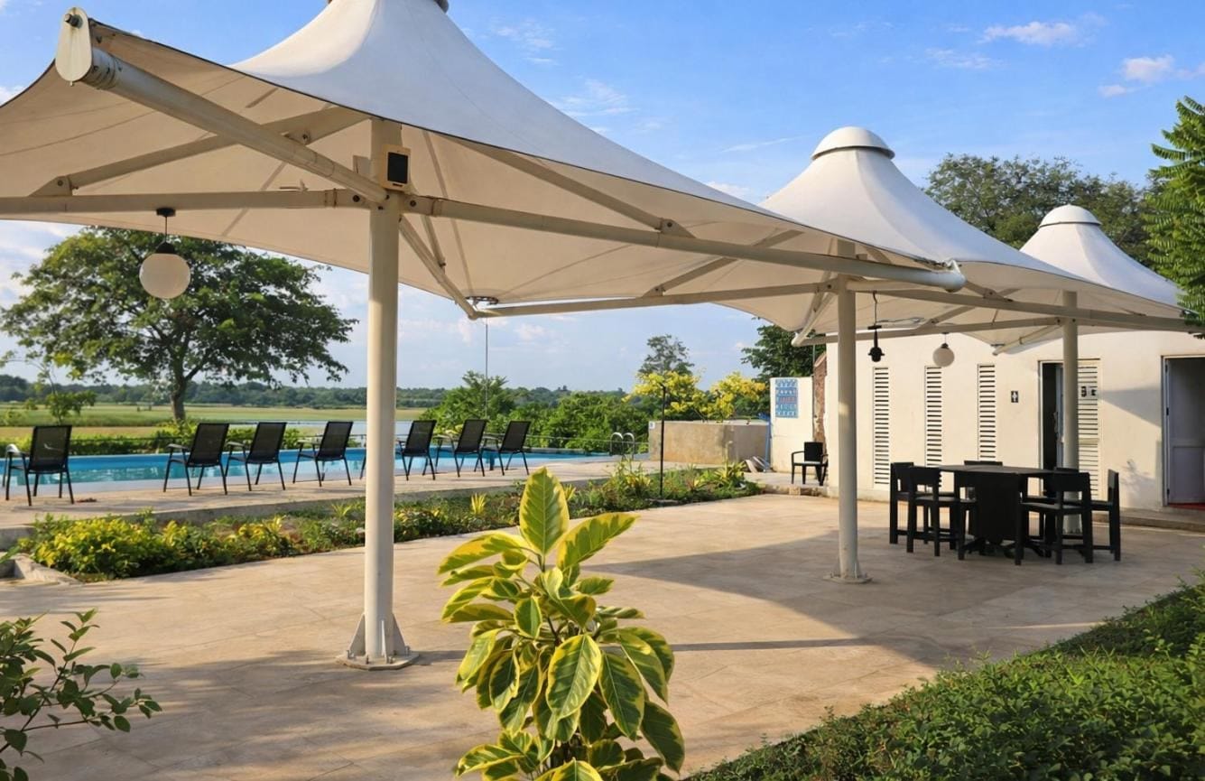 White canopy cabanas and outdoor dining beside the pool