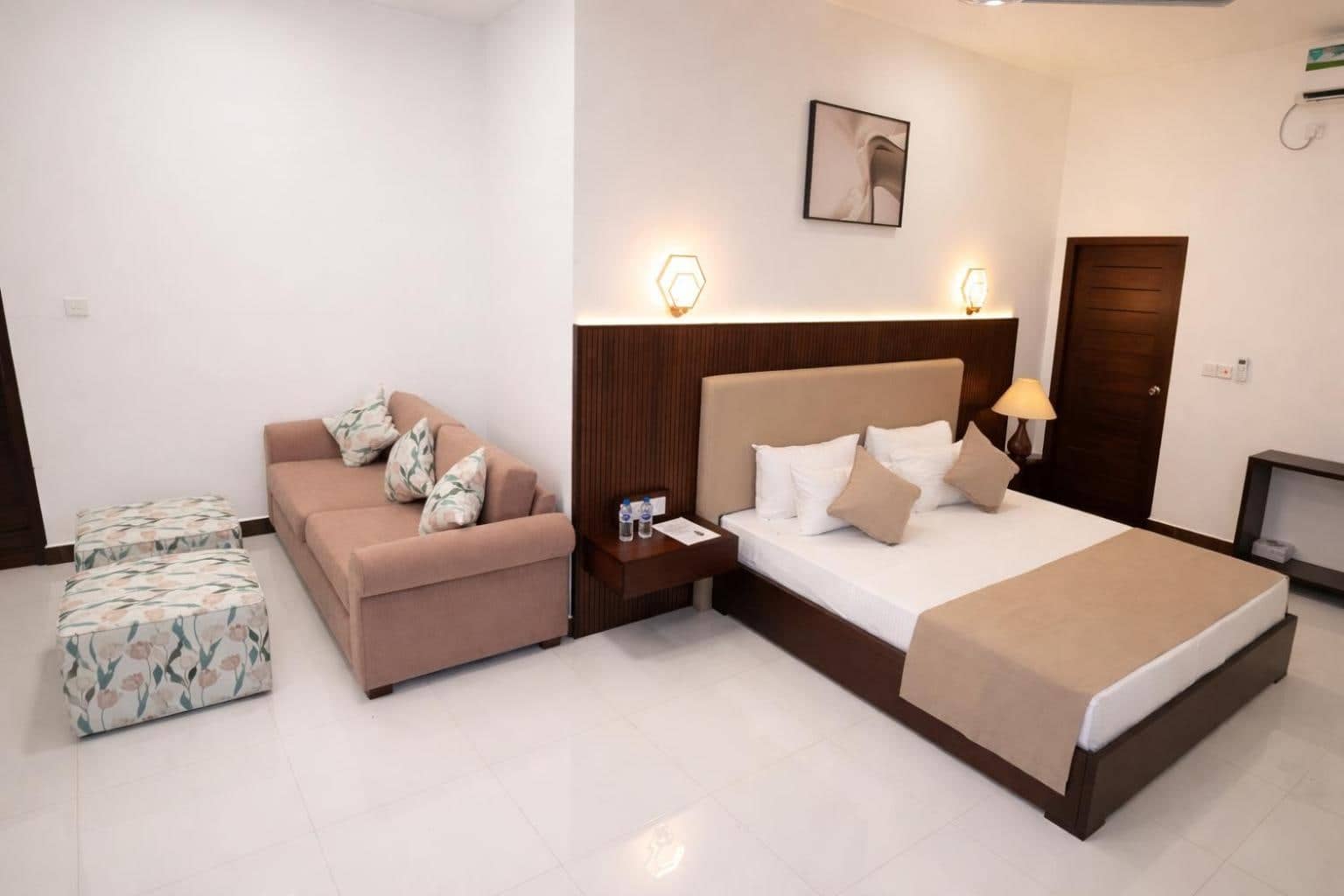 Room with queen bed and a blush sofa by the window